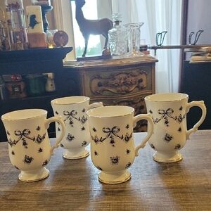 Reposhing-- Elegant White Ceramic Mugs with Black Bow Pattern - Set of 4